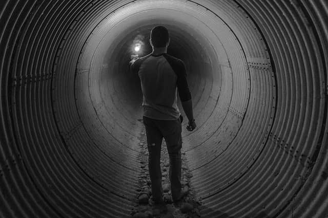 Picture of someone holding a light, alone in a tunnel. Incremental Software Development helps to avoid the tunnel effect when performing a large scale refactoring