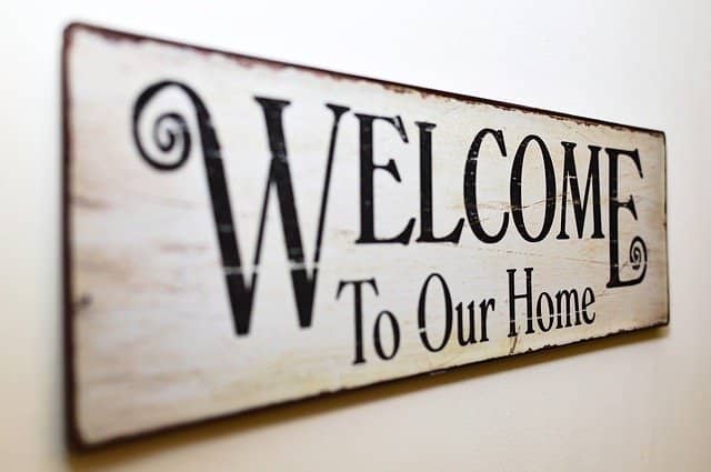 Photo of a sign written 'Welcome to our home'. Running a 'home tour' with your pair programming buddy is a fun remote collaboration tip that will kick off constructive work.
