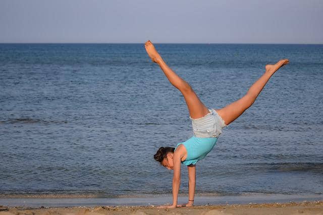 Photo of a girl practicing handstand on the beach. TCR is like weights that you add to your TDD drills, but, with even more fun!