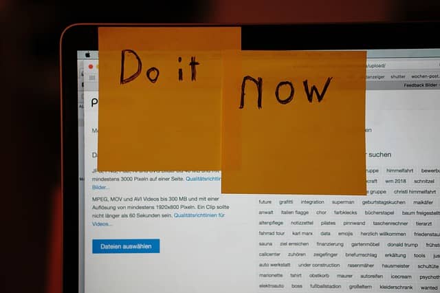 Photo of a laptop screen with post-its written "Do It Now" stuck on it. Design-Level Event Storming might seem daunting at first, but the best way is to get started.