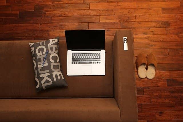 Photo of a laptop and a TV remote control on a sofa. In the current situation, we all have work from home. Pair programming or mob programming makes remote teams more effective