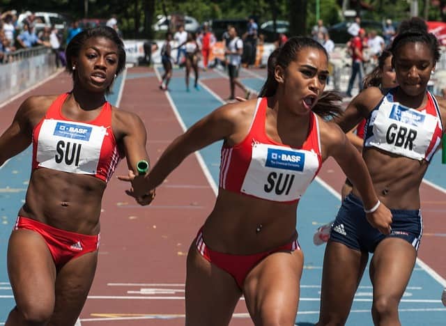 Photograph of athletics relay sprinters handing over the stick to each other. Technical coaching too can be a team sports. Sometimes, what one will have troubles with, the other will do easily!