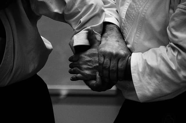 Close up photograph of the hands of aikido practitioners. Aikido is a non-violent martial art which goal is to destroy the attack rather than the aggressor. Good Aïkido should involve no strength and should be about accompanying the aggressor's dynamic towards peace. Likewise, we can use the organization's dynamics to get our request for a part-time coach role accepted.
