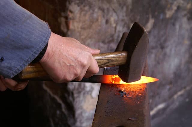 A photo of a blacksmith hammering hot iron on an anvil. Just after a successful workshop is the best time to continue and make big decisions fast.